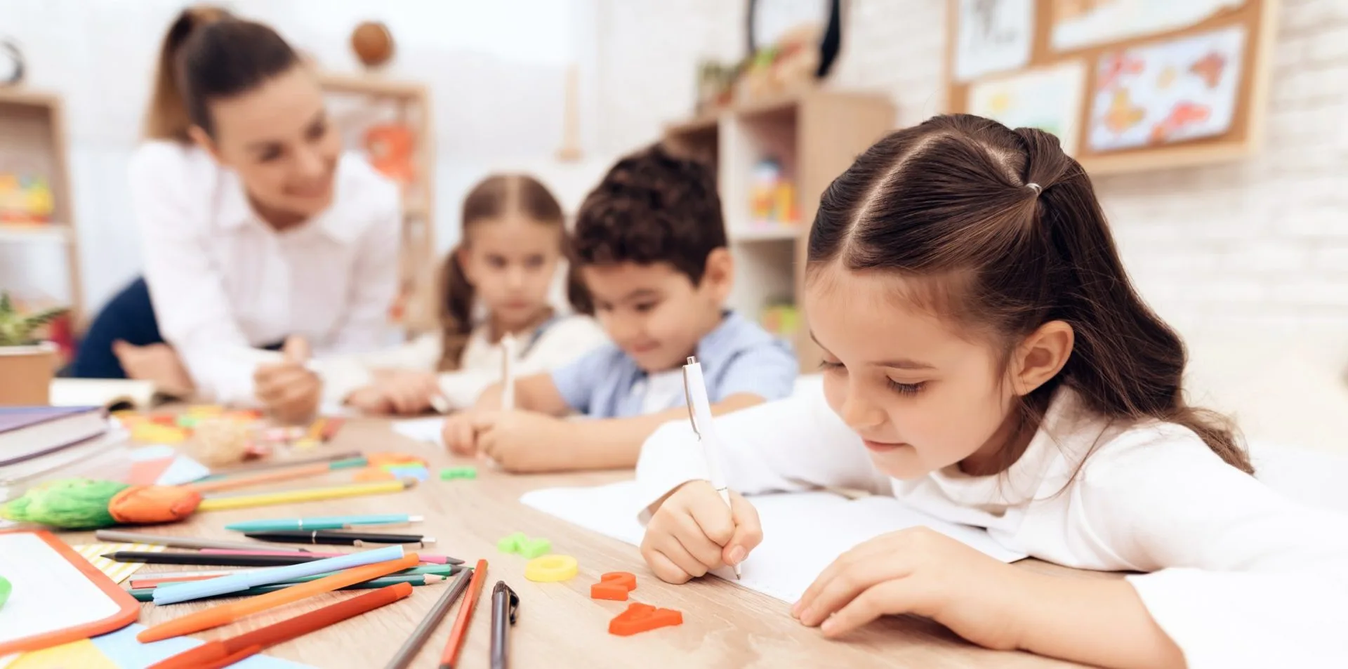 Children write in notebooks with a pen. Startsäit - Commune de Contern